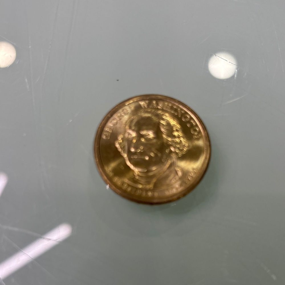 One dollar Gold tone George Washington dollar coin in mint condition